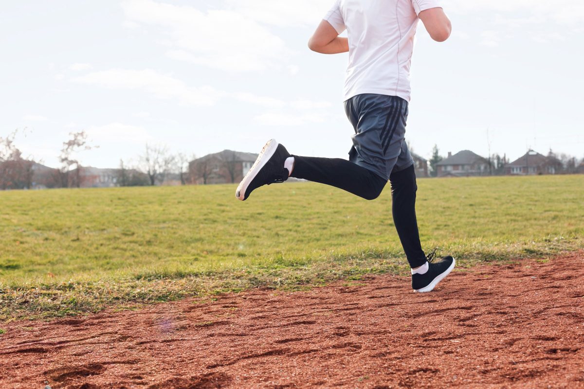 men's legs running on a field